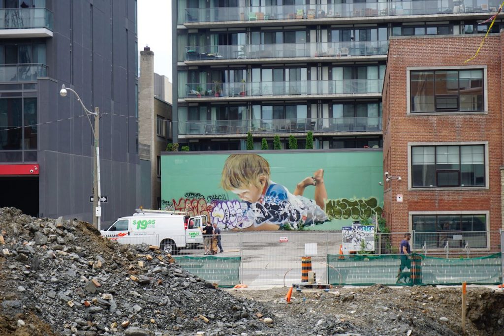 a huge mural of a toddler playing while lying on their stomach